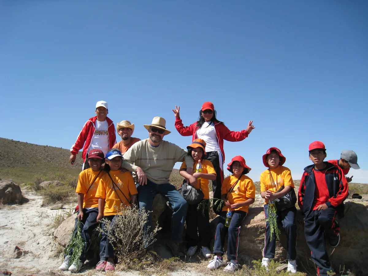 Man sieht einen Mann inmitten von Kindern.
